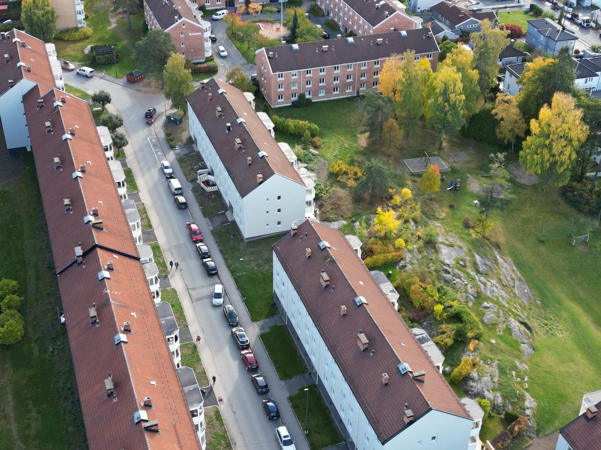 Dronefoto av tak og takrenner på boligbygg om høsten